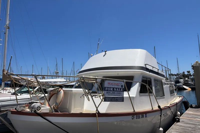 The Image of 1974 Skookum 34 boat for sale at marina, clear blue sky background. - 0