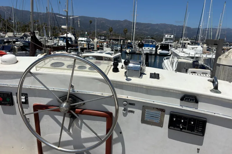 Slide: The Image of Steering wheel of a 1974 Skookum 34 boat docked in a marina. - 10