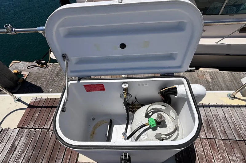 Slide: The Image of Open storage compartment on a 1974 Skookum 34 boat, revealing a propane tank. - 14