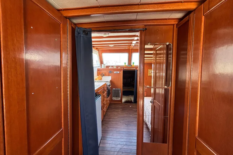 Slide: The Image of Interior of a 1974 Skookum 34 boat with wooden paneling and cozy cabin space. - 15