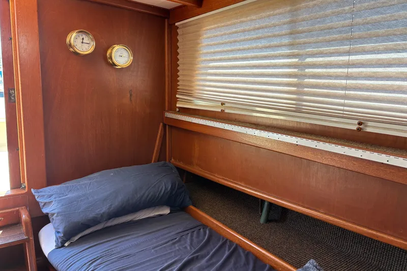 Slide: The Image of Cozy cabin interior of a 1974 Skookum 34 boat with wooden paneling and nautical instruments. - 18