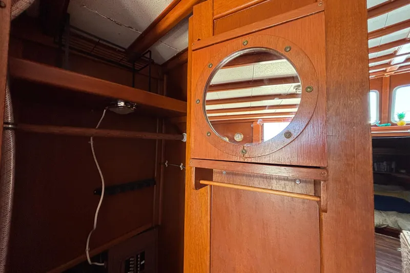 Slide: The Image of Interior of a 1974 Skookum 34 boat featuring wooden cabinetry and a round porthole. - 20