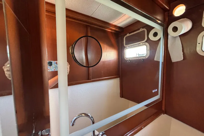 Slide: The Image of Bathroom interior of a 1974 Skookum 34 boat with mirror and porthole. - 23