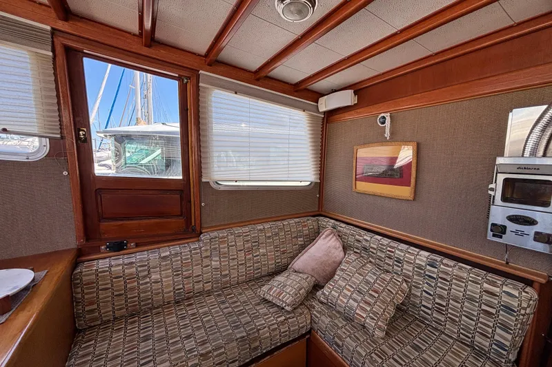 Slide: The Image of Cozy interior of a 1974 Skookum 34 boat with patterned seating and wooden accents. - 27