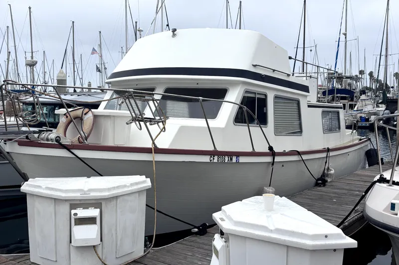 Slide: The Image of 1974 Skookum 34 boat docked at marina with sailboats in background. - 3