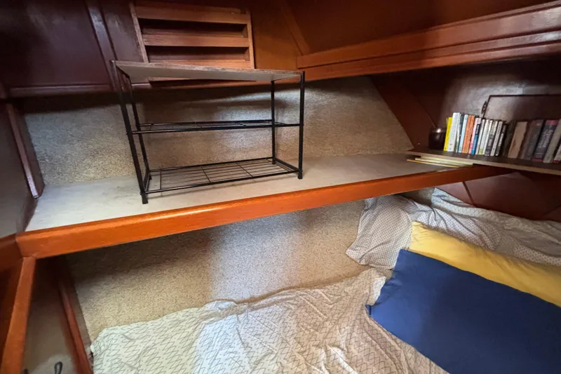 Slide: The Image of Cozy cabin interior of 1974 Skookum 34 sailboat with bed, shelf, and books. - 37