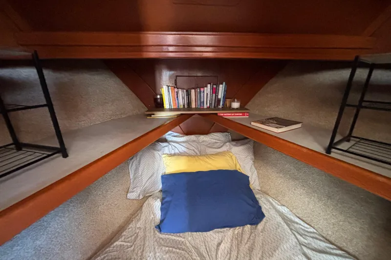 Slide: The Image of Cozy cabin interior of 1974 Skookum 34 sailboat with books and bedding. - 38