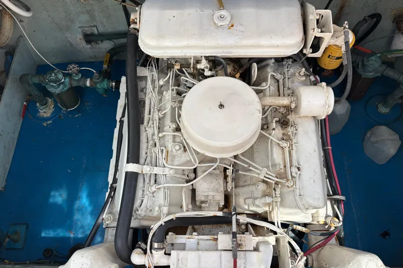 Slide: The Image of Engine compartment of a 1974 Skookum 34 boat, showcasing mechanical components and hoses. - 39