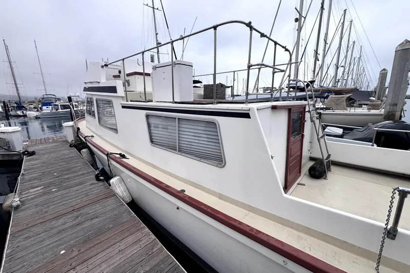 Slide: The Image of 1974 Skookum 34 boat docked at marina, featuring classic design and spacious deck. - 5