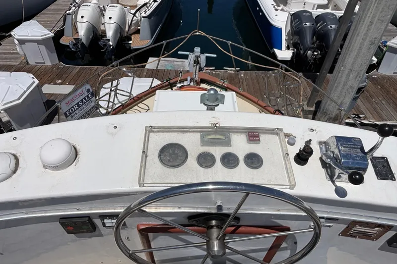 Slide: The Image of 1974 Skookum 34 boat dashboard with steering wheel and control panel at marina. - 8
