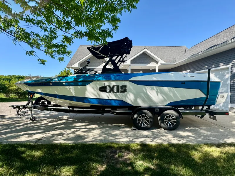 Slide: The Image of 2022 Axis Wake Research A24 boat on trailer in front of house. - 10