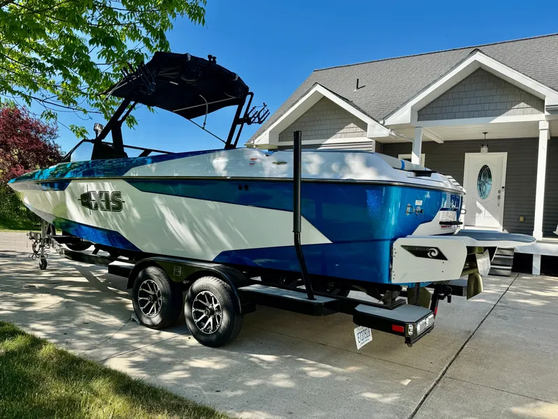 Slide: The Image of 2022 Axis Wake Research A24 boat on trailer in front of house. - 9