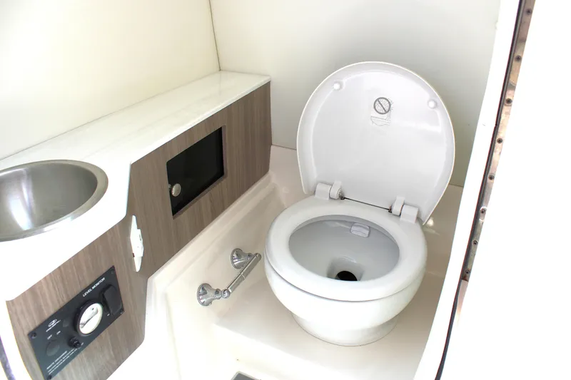 Slide: The Image of 2021 Regal 26 OBX boat bathroom with toilet and sink. - 10