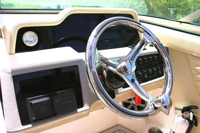 Slide: The Image of Steering wheel and dashboard of 2021 Regal 26 OBX boat, featuring modern controls. - 14