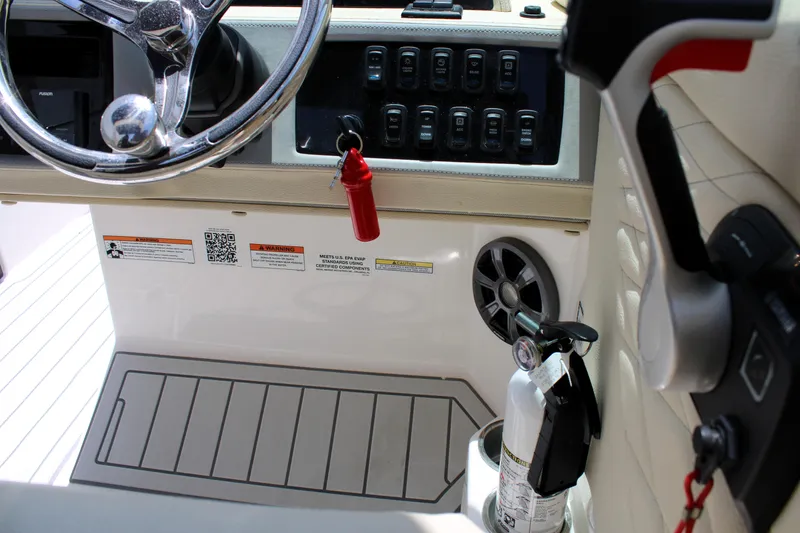 Slide: The Image of Interior of 2021 Regal 26 OBX boat showing steering wheel, controls, and safety equipment. - 17