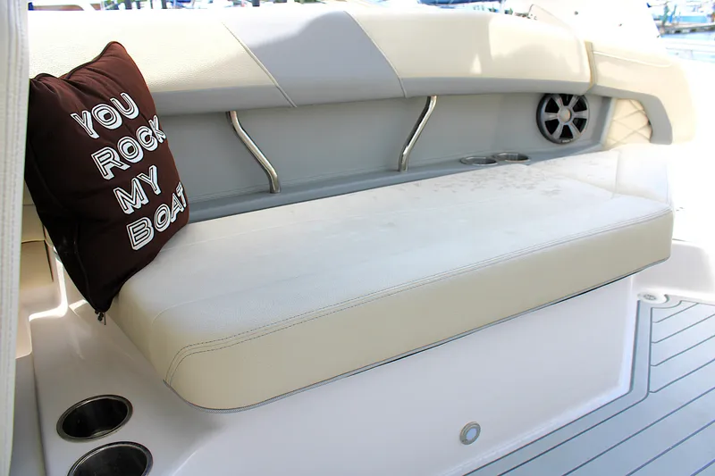 Slide: The Image of 2021 Regal 26 OBX boat interior with cushioned seating and decorative pillow. - 20