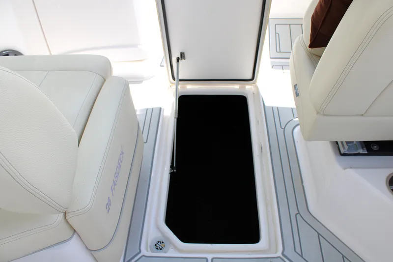 Slide: The Image of 2021 Regal 26 OBX boat interior with open storage compartment and cushioned seating. - 24