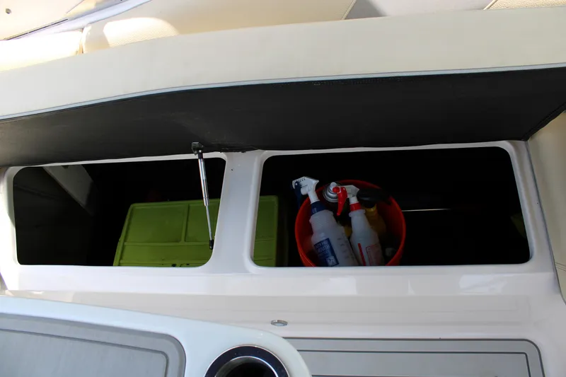 Slide: The Image of Storage compartment on a 2021 Regal 26 OBX boat with cleaning supplies. - 25