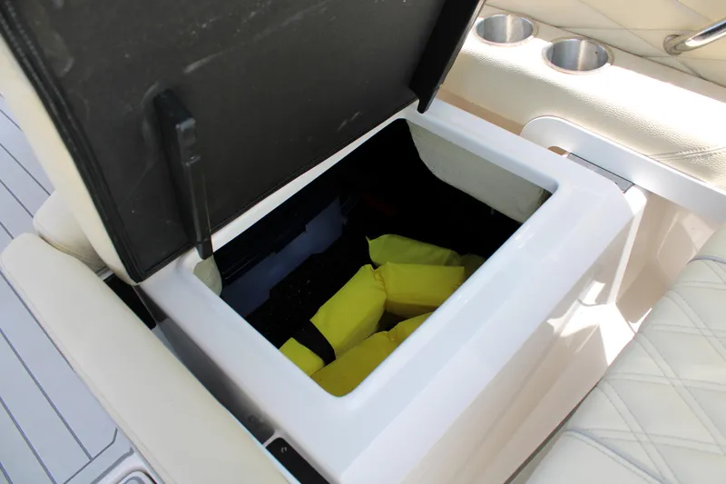 Slide: The Image of Storage compartment on 2021 Regal 26 OBX boat with yellow life jackets inside. - 28
