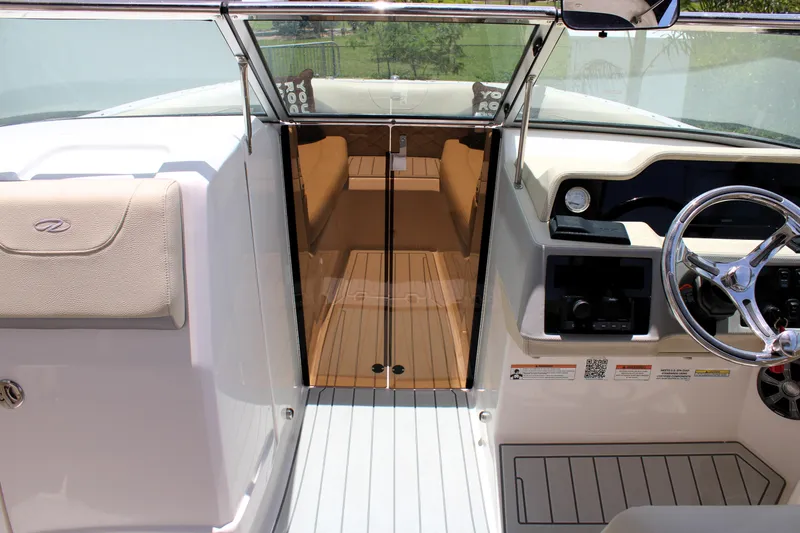 Slide: The Image of 2021 Regal 26 OBX boat interior with steering wheel and cabin entrance. - 29