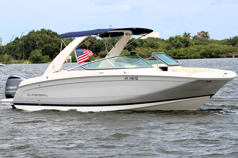 Slide: The Image of 2021 Regal 26 OBX boat on water with American flag and Yamaha engine. - 3