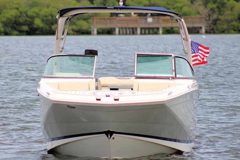 Slide: The Image of 2021 Regal 26 OBX boat on water with American flag, front view. - 4