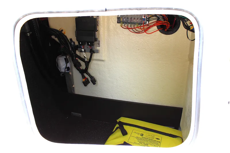 Slide: The Image of 2021 Regal 26 OBX boat storage compartment with wiring and safety equipment. - 41