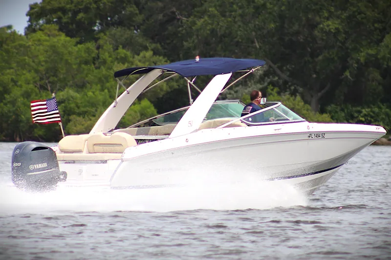 Slide: The Image of 2021 Regal 26 OBX boat cruising on water with American flag and Yamaha engine. - 43