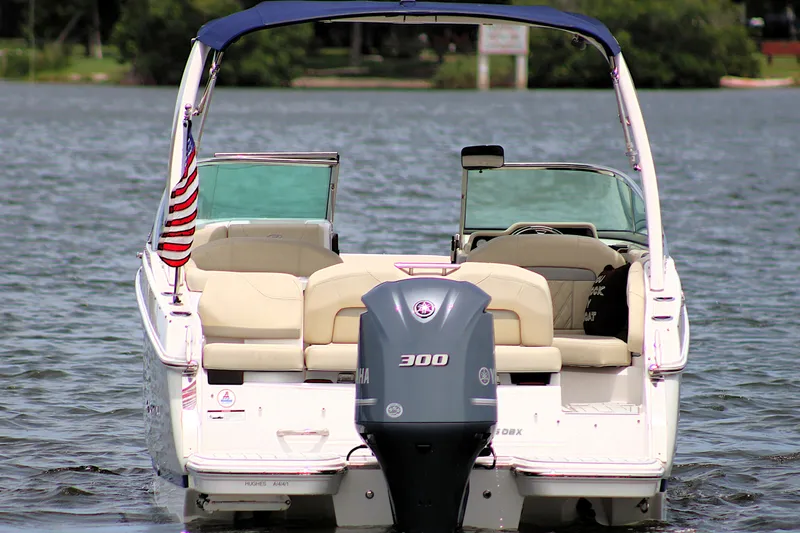 Slide: The Image of 2021 Regal 26 OBX boat with outboard motor on a lake. - 8
