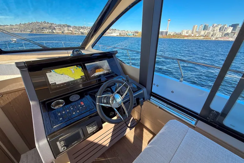 Slide: The Image of Cockpit view of 2027 Cruisers Yachts 50 Fly, overlooking city skyline and water. - 27