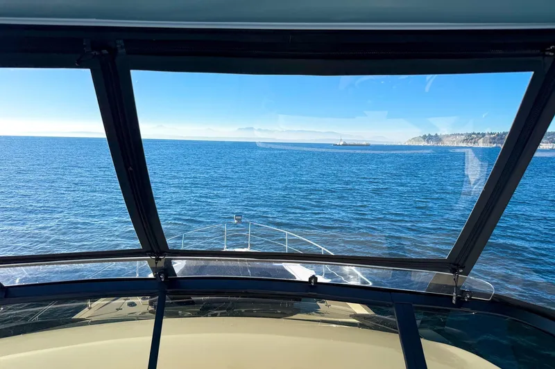 Slide: The Image of View from 2027 Cruisers Yachts 50 Fly, overlooking serene ocean and distant coastline. - 52