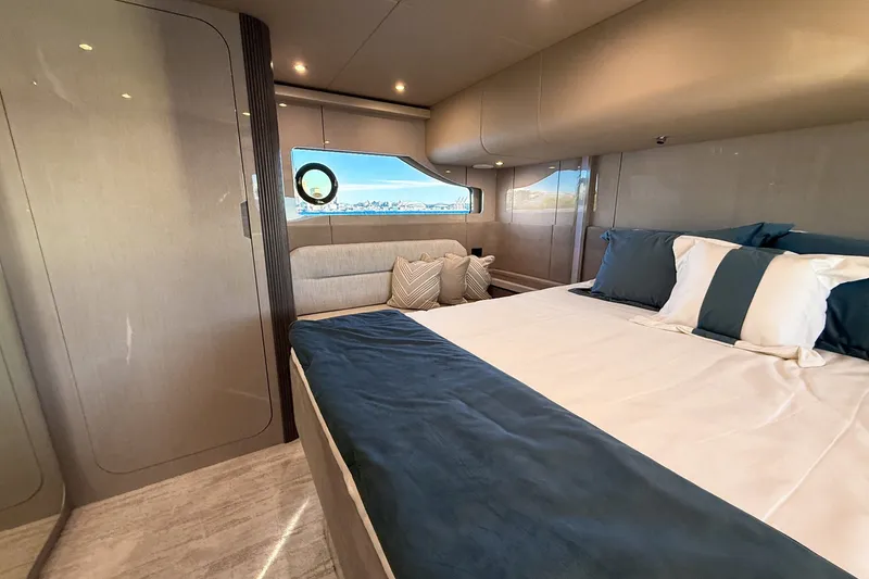 Slide: The Image of Luxurious bedroom interior of 2027 Cruisers Yachts 50 Fly with elegant bedding and window view. - 40