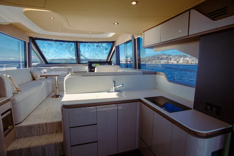 Slide: The Image of Luxurious interior of 2027 Cruisers Yachts 50 Fly with modern kitchen and panoramic windows. - 23