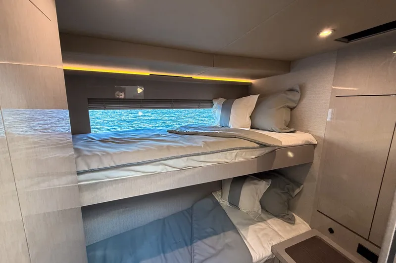 Slide: The Image of Luxurious cabin interior of 2027 Cruisers Yachts 50 Fly with bunk beds and ocean view. - 30