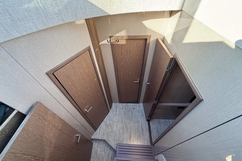 Slide: The Image of Interior view of 2027 Cruisers Yachts 50 Fly, featuring modern wooden doors and flooring. - 29