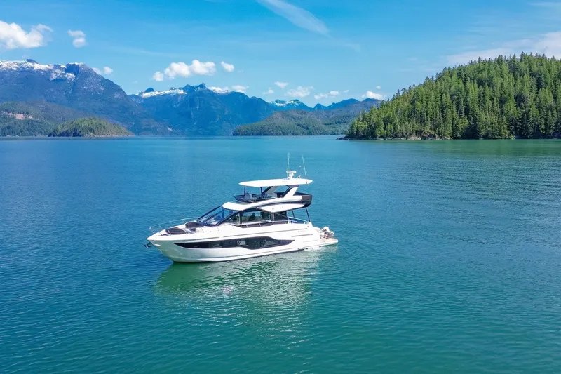 Slide: The Image of 2027 Cruisers Yachts 50 Fly on serene lake with mountain backdrop. - 5