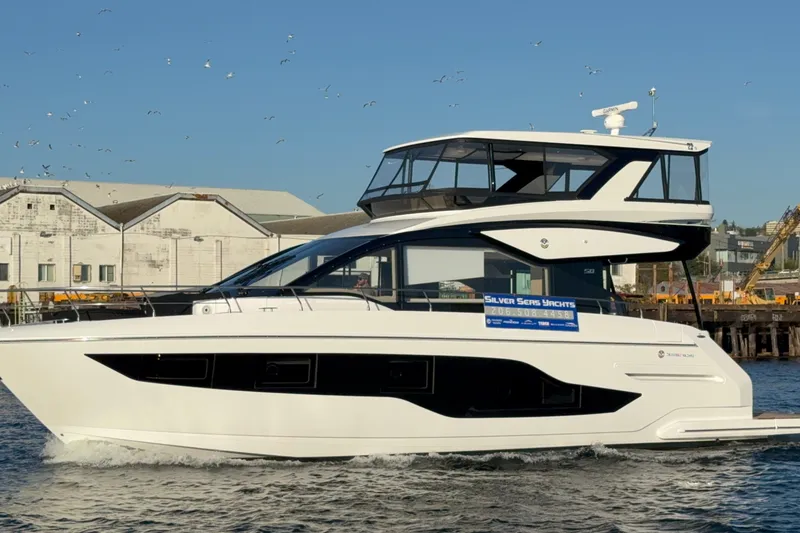 The Image of 2027 Cruisers Yachts 50 Fly luxury yacht on water, sleek design, sunny day. - 1