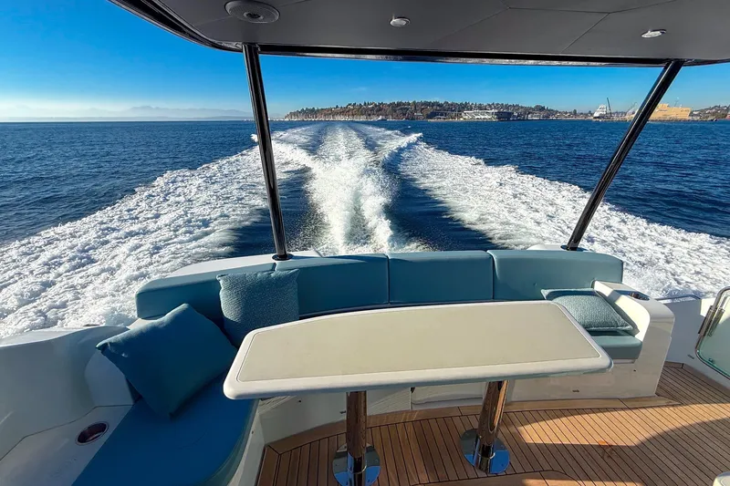 Slide: The Image of Luxurious 2027 Cruisers Yachts 50 Fly cruising on open water, featuring elegant seating and table. - 25