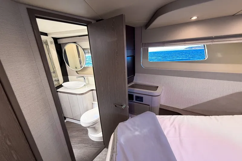 Slide: The Image of Luxurious interior of 2027 Cruisers Yachts 50 Fly, featuring a bedroom and bathroom with ocean view. - 33
