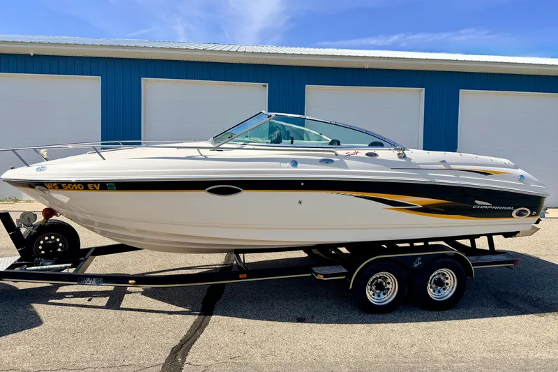 Slide: The Image of 2000 Chaparral 235 SSi boat on trailer, parked near blue garage doors. - 1