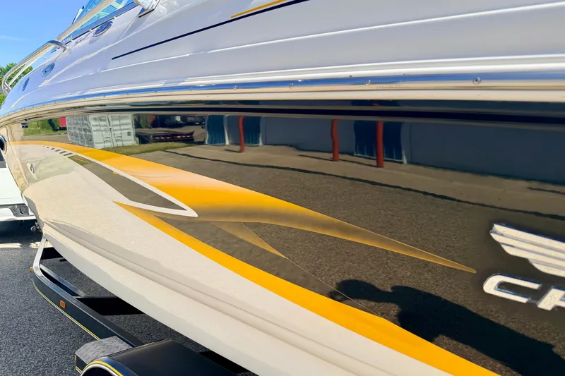 Slide: The Image of 2000 Chaparral 235 SSi boat with sleek yellow and white design on trailer. - 13