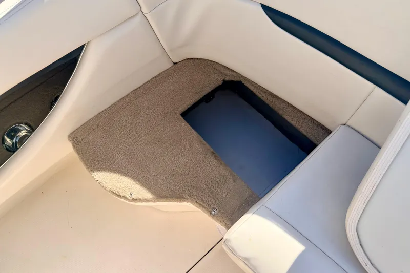 Slide: The Image of Interior view of a 2000 Chaparral 235 SSi boat showing a carpeted storage compartment. - 25