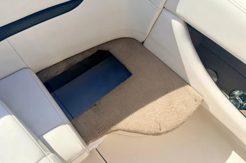 Slide: The Image of Interior view of a 2000 Chaparral 235 SSi boat, featuring beige carpet and white seating. - 28