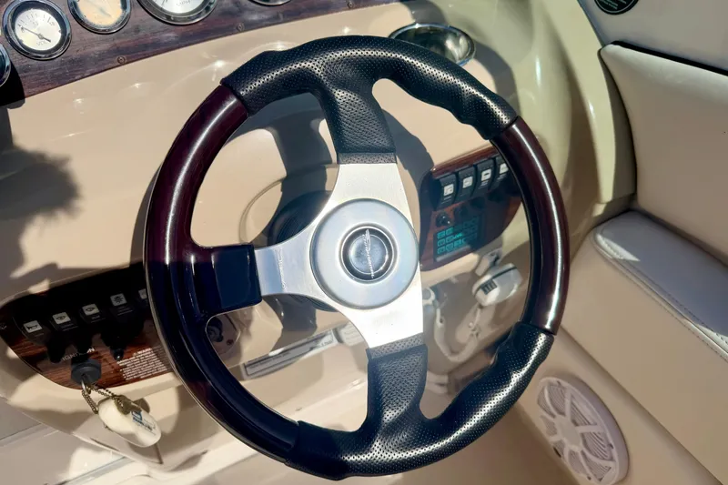 Slide: The Image of Steering wheel of a 2000 Chaparral 235 SSi boat, featuring gauges and controls. - 35