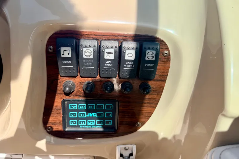 Slide: The Image of Control panel of a 2000 Chaparral 235 SSi boat with various switches and stereo controls. - 38
