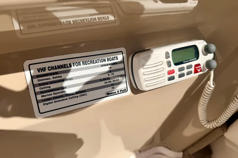 Slide: The Image of VHF radio and channel guide on 2000 Chaparral 235 SSi boat dashboard. - 39