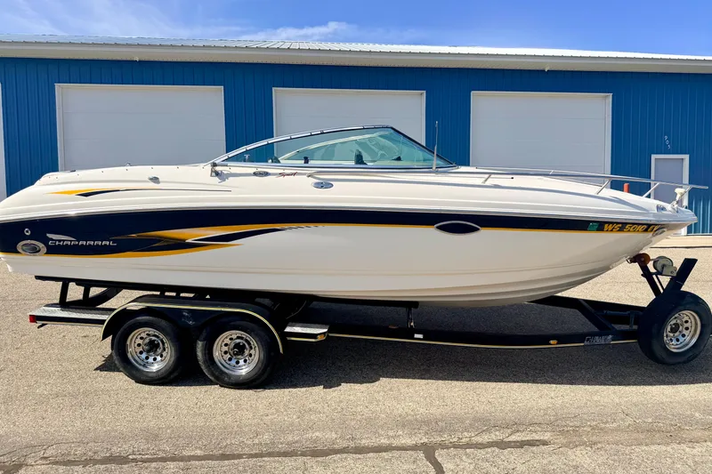 Slide: The Image of 2000 Chaparral 235 SSi boat on trailer, parked outside blue building. - 4