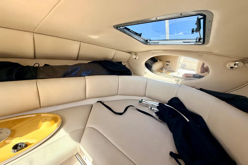 Slide: The Image of Interior of 2000 Chaparral 235 SSi boat with beige seating and open hatch. - 55