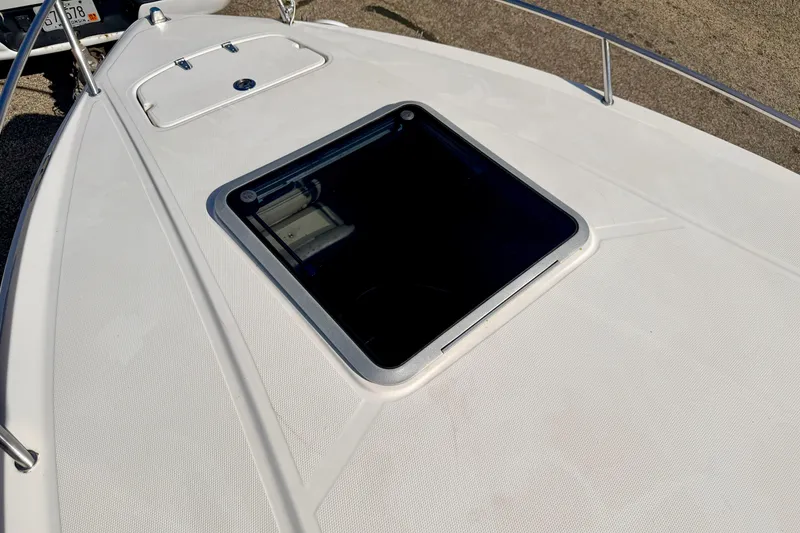 Slide: The Image of 2000 Chaparral 235 SSi boat deck with hatch, featuring sleek white design. - 59