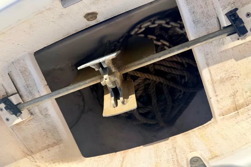 Slide: The Image of Anchor storage compartment on a 2000 Chaparral 235 SSi boat, featuring rope and anchor. - 61